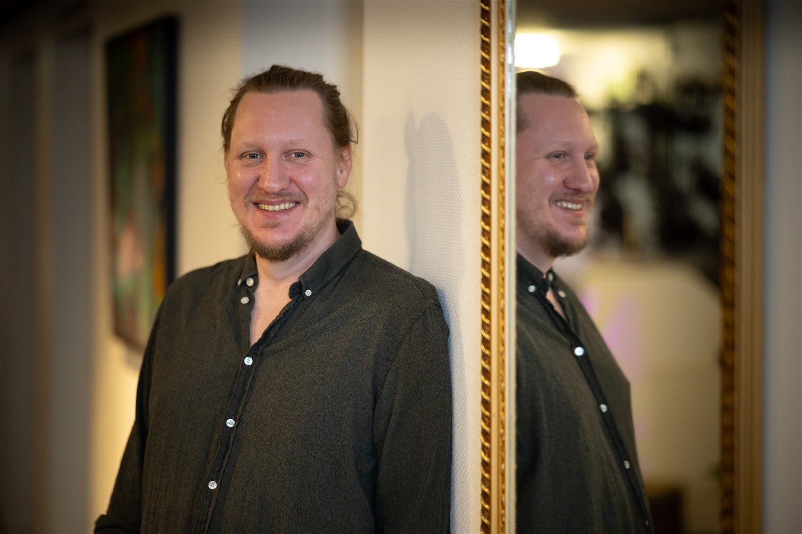 Erik Sjösten Andersson smiling beside a mirror
